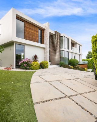A Driveway of a contemporary house with a garden area