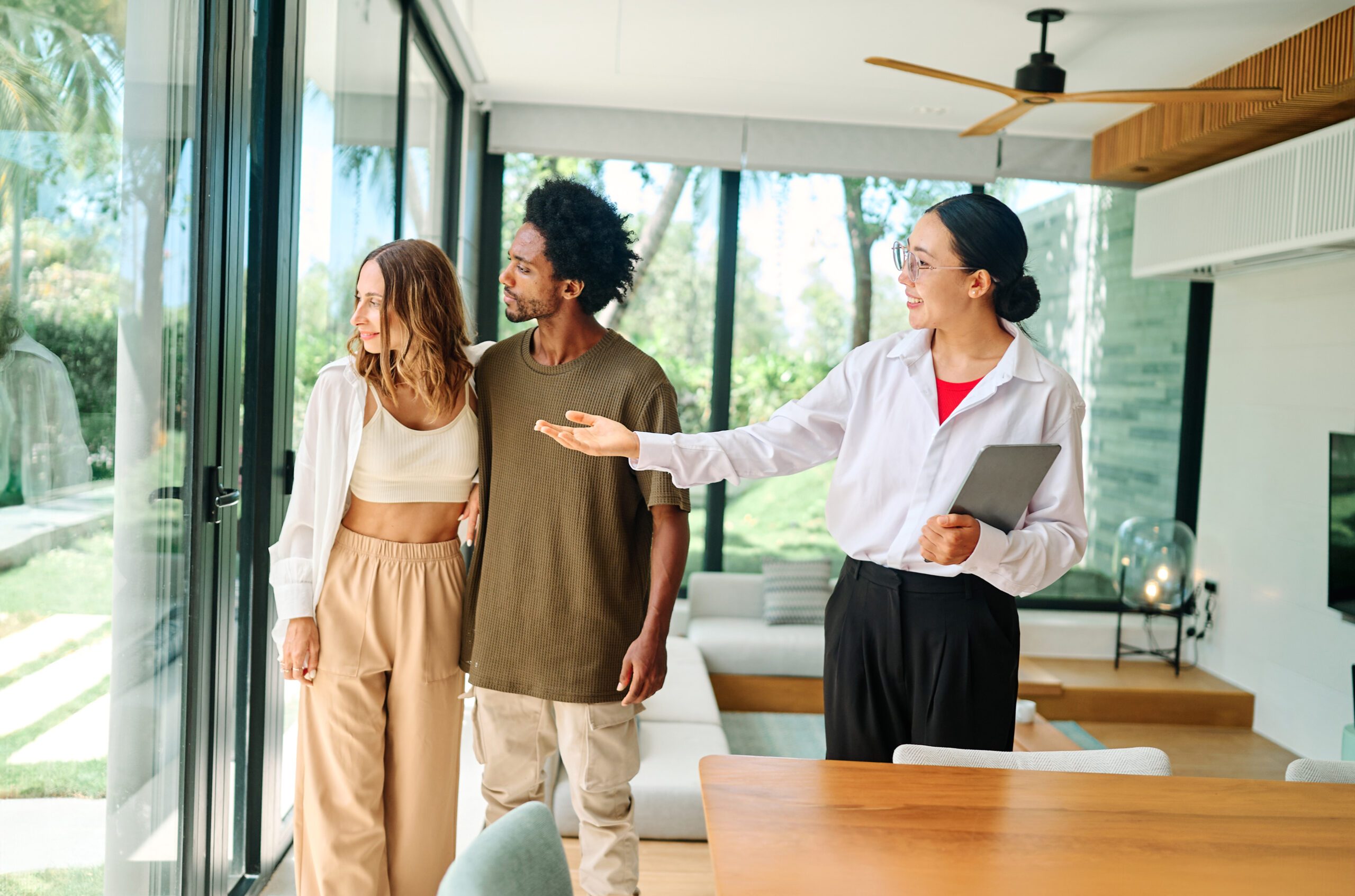 Young happy couple and an agent in a new property